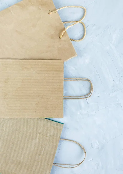 Flat lay of paper wastes as bags, boxes ready for recycling on gray background. Ecology care and social responsibility concept