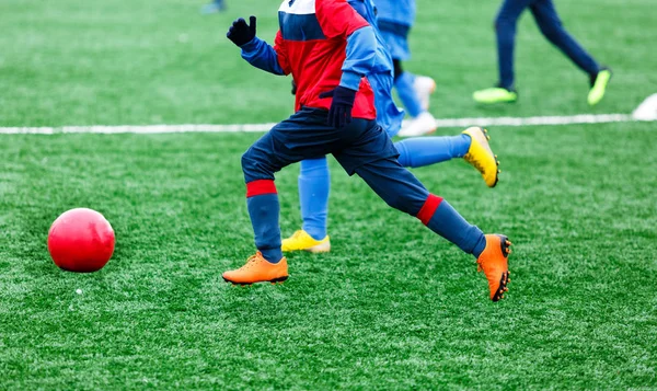 Two young Footballers running,dribble and competing for ball. Junior football match competition. Winter activities, soccer game, training concept