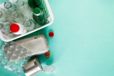 farklı atıkların yeşil zemin üzerine beyaz sepet içinde geri dönüşüm için hazır. Plastik şişeler, cam-yumurta tepsi. Sosyal sorumluluk, ekoloji bakımı, evde kavramı geri dönüşüm