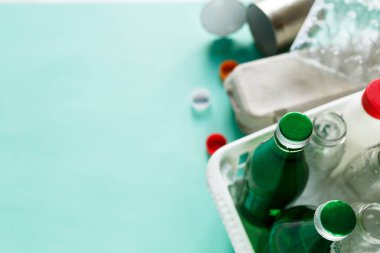 farklı atıkların yeşil zemin üzerine beyaz sepet içinde geri dönüşüm için hazır. Plastik şişeler, cam-yumurta tepsi. Sosyal sorumluluk, ekoloji bakımı, evde kavramı geri dönüşüm