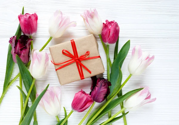 colorful beautiful tulips and gift box on the white wooden table. Valentines, spring background. floral mock up with copyspace. happy mothers day, romantic still life, fresh flowers