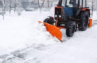 Kar temizleme. Traktör temizler road, yoğun kar yağışı sonra yol. Traktör yolda kar temizleme. Ekskavatör büyük miktarda kar City sokaklarında temizler. 