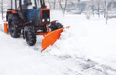 Kar temizleme. Traktör temizler road, yoğun kar yağışı sonra yol. Traktör yolda kar temizleme. Ekskavatör büyük miktarda kar City sokaklarında temizler. 