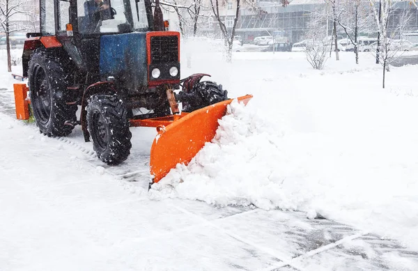 Snow clearing. Tractor clears road, way after heavy snowfall. Tractor cleaning the road from the snow. Excavator cleans the streets of large amounts of snow in city.