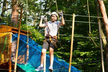 Sevimli çocuk macera parkı güneşli yaz gününde tırmanma etkinliğini zevk. İp Bahçesi yapısında tırmanma çocuk. Kask sigorta ile tırmanma güvenli. Çocuk orman macera parkı, aşırı spor