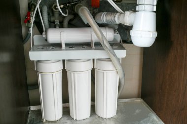  Ters ozmoz su arıtma sistemi evde. Mutfak altında su arıtma filtreleri yüklemesini lavabo dolapta. Temiz su kavramı