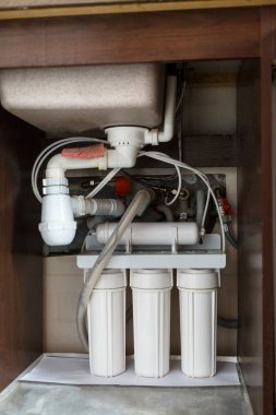  Ters ozmoz su arıtma sistemi evde. Mutfak altında su arıtma filtreleri yüklemesini lavabo dolapta. Temiz su kavramı