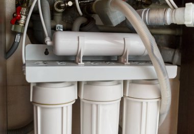  Ters ozmoz su arıtma sistemi evde. Mutfak altında su arıtma filtreleri yüklemesini lavabo dolapta. Temiz su kavramı