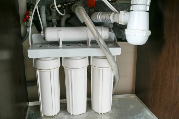  Ters ozmoz su arıtma sistemi evde. Mutfak altında su arıtma filtreleri yüklemesini lavabo dolapta. Temiz su kavramı