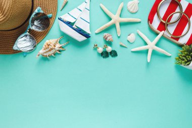 Tropic düz saman şapka, çanta, yıldız balığı, kabukları, güneş gözlüğü, tekne, yeşil arka planda küpe ile yatıyordu. Yaz moda düz yatıyordu, tatil, seyahat kavramı. Kopya alanı ile üst görünüm. 