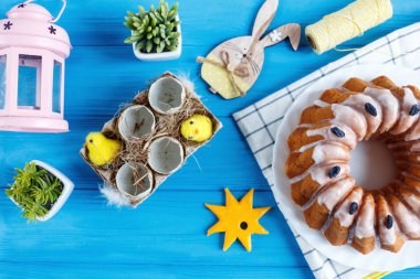 Mutlu Paskalyalar! Havlu, yumurta, ahşap tavşan rabit mavi ahşap arka plan olarak el yapımı kek. Paskalya tatili için dekorasyon