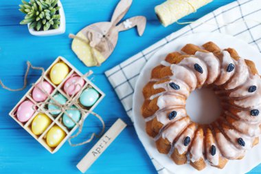 Mutlu Paskalyalar! Havlu, yumurta, ahşap tavşan rabit mavi ahşap arka plan olarak el yapımı kek. Paskalya tatili için dekorasyon