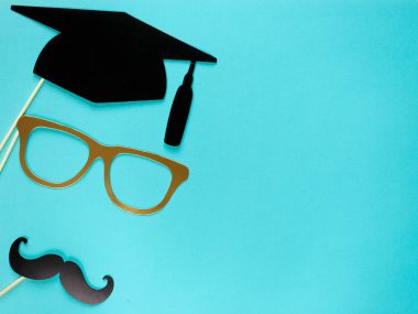 Mezuniyet photobooth aksesuarlar ile yaratıcı arka plan: şapka, diploma, Gözlük, dudakları parlak mavi Kağıt arka plan üzerinde. Eğitim, çalışma kavramı. 