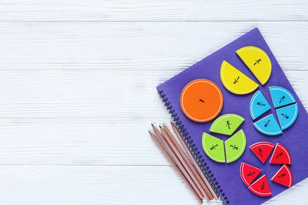 Beyaz ahşap masada matematik renkli parlak kesirler. çocuklar için ilginç matematik. Eğitim, okul konseptine geri dön