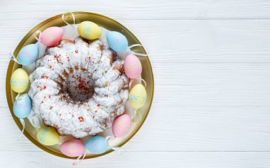 Mutlu Paskalya! Altın tepsi plaka pasta ve el ahşap masada renkli yumurta boyalı. Kapat şunu. Paskalya için dekorasyon, şenlikli arka plan.