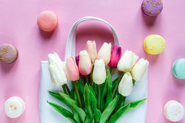 Pembe arka planda pembe laleler ve badem kurabiyeleri. en üstteki görünüm. 