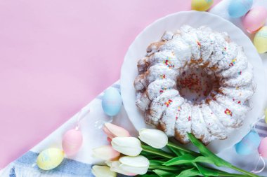 Mutlu Paskalya! Kek ve el boyalı renkli yumurta, lale ve beyaz arka planda büyük plaka. Kapat şunu. Paskalya için dekorasyon, şenlikli arka plan.