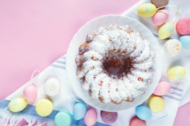 Mutlu Paskalya! Kek ve el boyalı renkli yumurta, lale ve beyaz arka planda büyük plaka. Kapat şunu. Paskalya için dekorasyon, şenlikli arka plan.