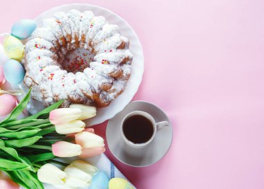 Mutlu Paskalya! Kek ve el boyalı renkli yumurta, lale ve beyaz arka planda büyük plaka. Kapat şunu. Paskalya için dekorasyon, şenlikli arka plan.
