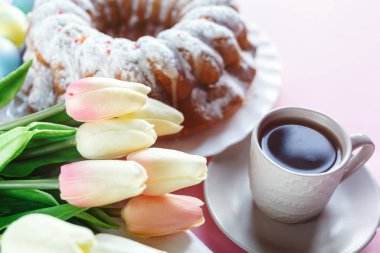 Mutlu Paskalya! Kek ve el boyalı renkli yumurta, lale ve beyaz arka planda büyük plaka. Kapat şunu. Paskalya için dekorasyon, şenlikli arka plan.