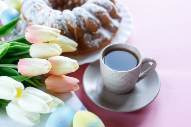 Mutlu Paskalya! Kek ve el boyalı renkli yumurta, lale ve beyaz arka planda büyük plaka. Kapat şunu. Paskalya için dekorasyon, şenlikli arka plan.