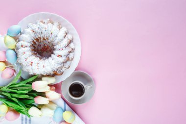 Mutlu Paskalya! Kek ve el boyalı renkli yumurta, lale ve beyaz arka planda büyük plaka. Kapat şunu. Paskalya için dekorasyon, şenlikli arka plan.