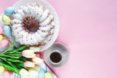 Mutlu Paskalya! Kek ve el boyalı renkli yumurta, lale ve beyaz arka planda büyük plaka. Kapat şunu. Paskalya için dekorasyon, şenlikli arka plan.