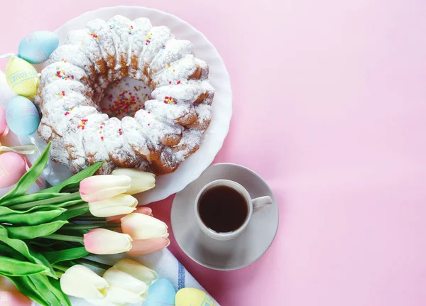 Mutlu Paskalya! Kek ve el boyalı renkli yumurta, lale ve beyaz arka planda büyük plaka. Kapat şunu. Paskalya için dekorasyon, şenlikli arka plan.