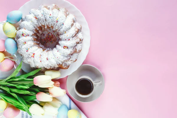 Mutlu Paskalya! Kek ve el boyalı renkli yumurta, lale ve beyaz arka planda büyük plaka. Kapat şunu. Paskalya için dekorasyon, şenlikli arka plan.