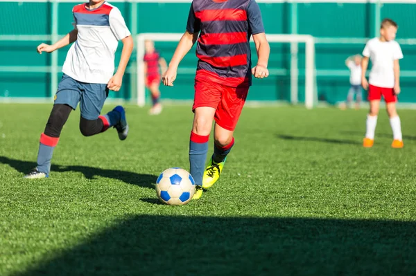 축구장에서 빨간색 운동복에 드리블 게임에 활동적인 라이프 스타일 스포츠 어린이 — 스톡 사진