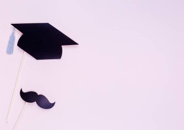 Mezuniyet photobooth aksesuarlar ile yaratıcı arka plan: şapka, diploma, gözlük, pastel pembe kağıt arka plan dudaklarından. Eğitim, çalışma kavramı. 