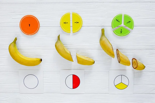 五颜六色的数学分数和香蕉作为白色木制背景或桌子上的样本 有趣的数学为孩子们 回到学校的概念 几何和数学材料 — 图库照片