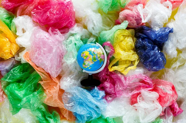 globe on the background of multi-colored plastic bags