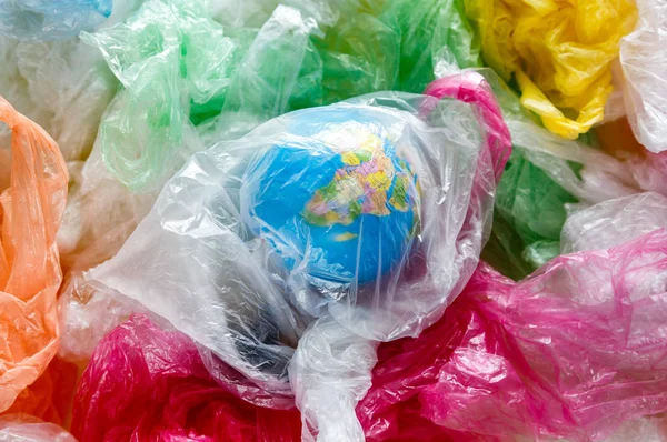 globe in a plastic bag on the background of multi-colored plastic bags