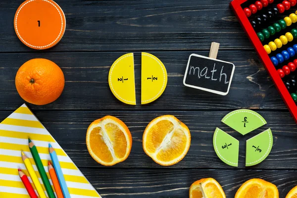 五颜六色的数学分数和橙色作为样品在黑暗的木制背景或桌子上 有趣的创意有趣的数学为孩子们 回到学校的概念 几何和数学材料 — 图库照片