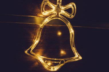 Altın mücevherlerle süslenmiş şık bir Noel çanı aydınlatması, ev içinde altın ışıklar çakışıyor. Noel dekoru. Mevsimlik tebrik kartı. Tatil geçmişi. Yanıp sönen Çelenkler.