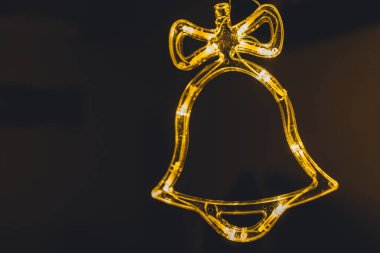 Altın takılarla süslenmiş şık bir Noel çanı aydınlatması. Noel dekoru. Mevsimlik tebrik kartı. Tatil geçmişi. Yanıp sönen Çelenkler.