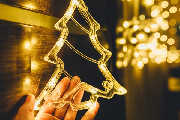 Frau Hält Stilvolle Weihnachtsbaumbeleuchtung Mit Goldenen Kugeln Goldene Lichter Bokeh — Stockfoto