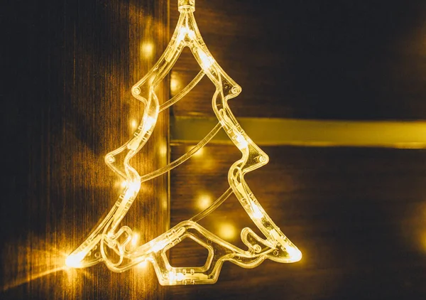 女人手里拿着金黄色的圣诞灯饰 金黄色的灯饰在家中摇曳 圣诞装饰 节日贺卡 度假背景 眨眼花环 — 图库照片