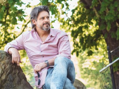 Poz ve tarafına bakarak muhteşem yetişkin bir adam. Profil güzel rahat işadamı, dış