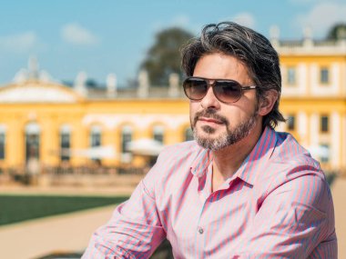 Mor - pembe şık gömlek ile güneş gözlüğü, açık, kendinden emin ve yakışıklı erkek işadamı dışında tek