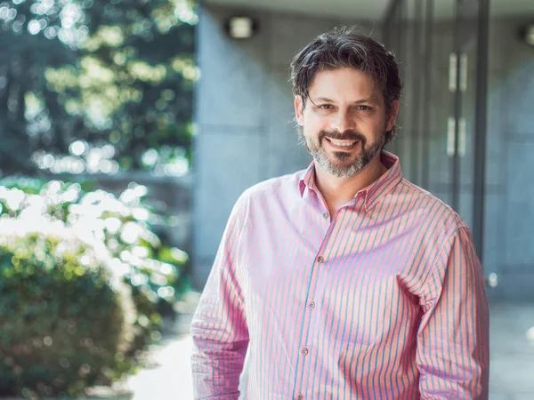 Dışarıda gülümseyen yetişkin yakışıklı adam portresi. Sakallı gülümseme işadamı