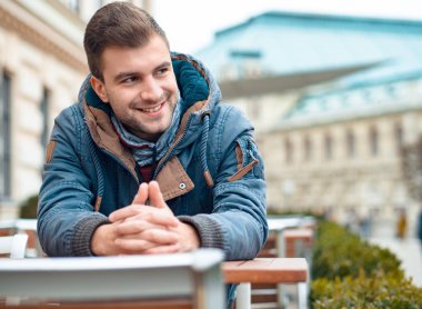 Yan, dış mekan, dışında isteyen yakışıklı genç gülümseyen.