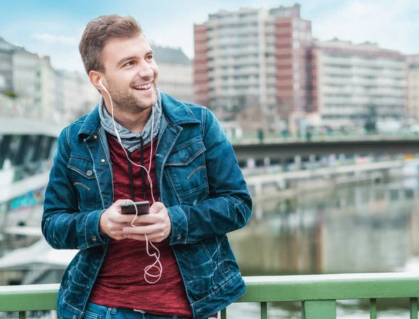 Jovem Satisfeito Ouvindo Faixas Mensagens Texto Amigos Usando Telefone Celular — Fotografia de Stock