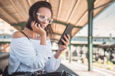 SMS Smartphone'da tipik ve bir trai için bekleyen genç kadın