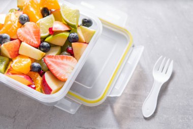 Plastik kutuda ya da kabın içinde meyve salatası paketlenmiş. Sağlıklı bir yemek.