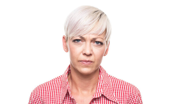 Нахмуренная взрослая женщина с выражением гнева смотрит на тебя, изолированная на белом фоне. Злая женщина средних лет крупным планом. Снимок студии