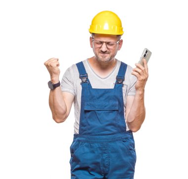 Sinirli orta yaşlı inşaat işçisi telefonda konuşuyor, beyaz arka planda izole edilmiş. Sinirli tamirci konuşuyor. Stresli insan akıllı telefon kullanıyor. Stüdyo çekimi