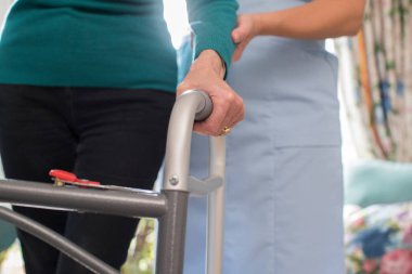 Çerçeve bakım işçisi ile arka planda yürüyen üst düzey Womans ellerde