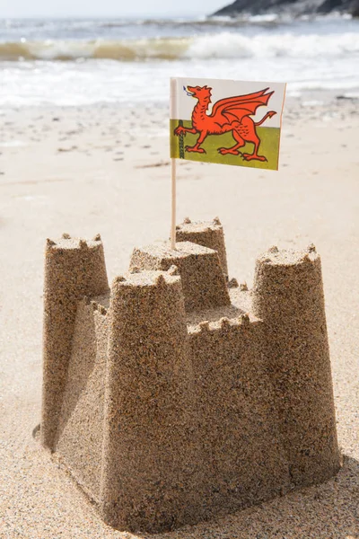 Sandcastle On Beach Flying Welsh Flag